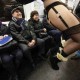 People watch as participants in the No Pants Subway Ride take the 6 train downtown in New York