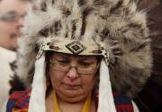Attawapiskat Chief Theresa Spence, wearing a headdress, takes part in a drum ceremony before departing a Ottawa hotel to attend a ceremonial meeting at Rideau Hall with Gov. Gen. David Johnston in Ottawa, Friday January 11, 2013. THE CANADIAN PRESS/Fred Chartrand