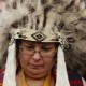 Attawapiskat Chief Theresa Spence, wearing a headdress, takes part in a drum ceremony before departing a Ottawa hotel to attend a ceremonial meeting at Rideau Hall with Gov. Gen. David Johnston in Ottawa, Friday January 11, 2013. THE CANADIAN PRESS/Fred Chartrand